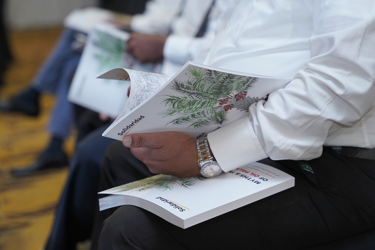 Attendee flips through Myths and Truths of Palm Oil book