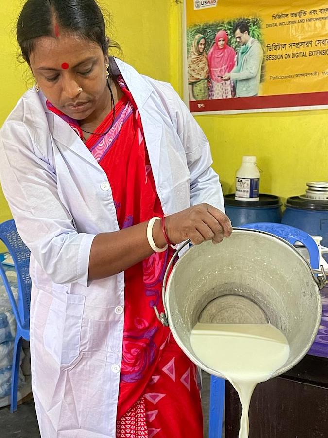 Nivedita Vishwas empties milk into a collection tank