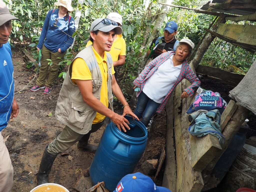 A technician from Solidaridad Peru demonstrates how to create homemade fertilizers using waste water from the coffee washing process.