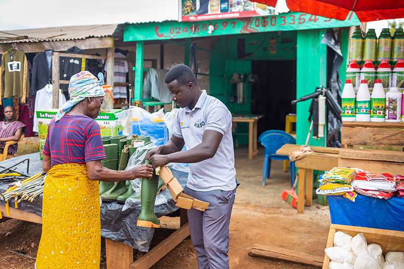 Andrew Fosu helps a client at his agro-input shop