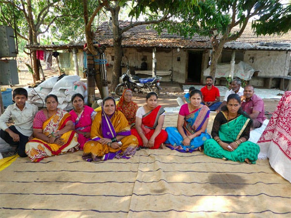 The women of Basarge Gad, discussing their VSI training experiences. Their husbands sit in the background